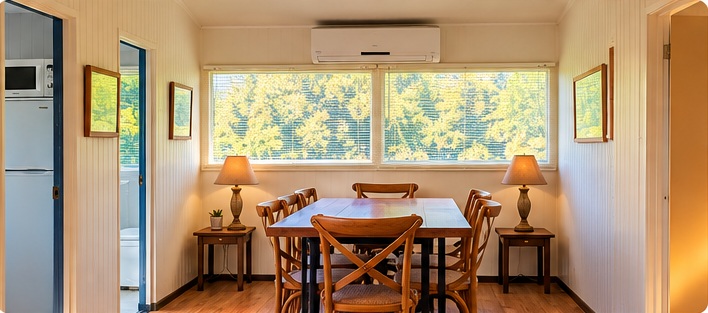 Comedor de la cabaña con ventanales hacia el bosque